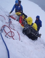 TMRU team securing a patient in a litter on steep snow. TMRU photo.