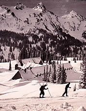 Skiers above Paradise Inn with the Tatoosh Range in the distance, 1930s. Photo by Dwight Watson.