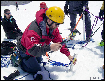 Placing a picket anchor in the snow. Photo © Portland Mountain Rescue.